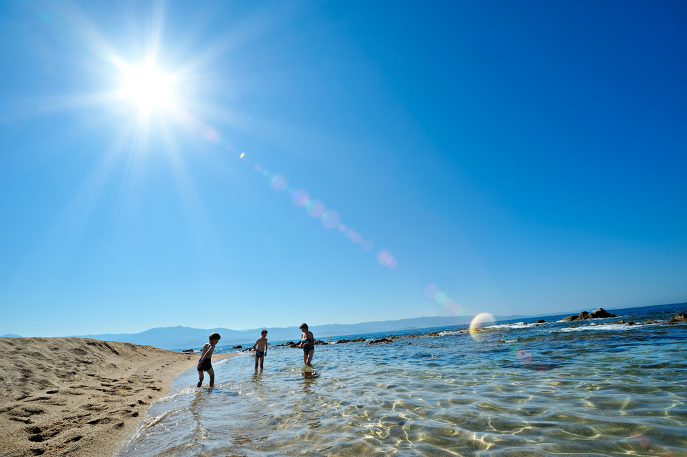 Person enjoying safe sun exposure for natural vitamin D with sunscreen nearby