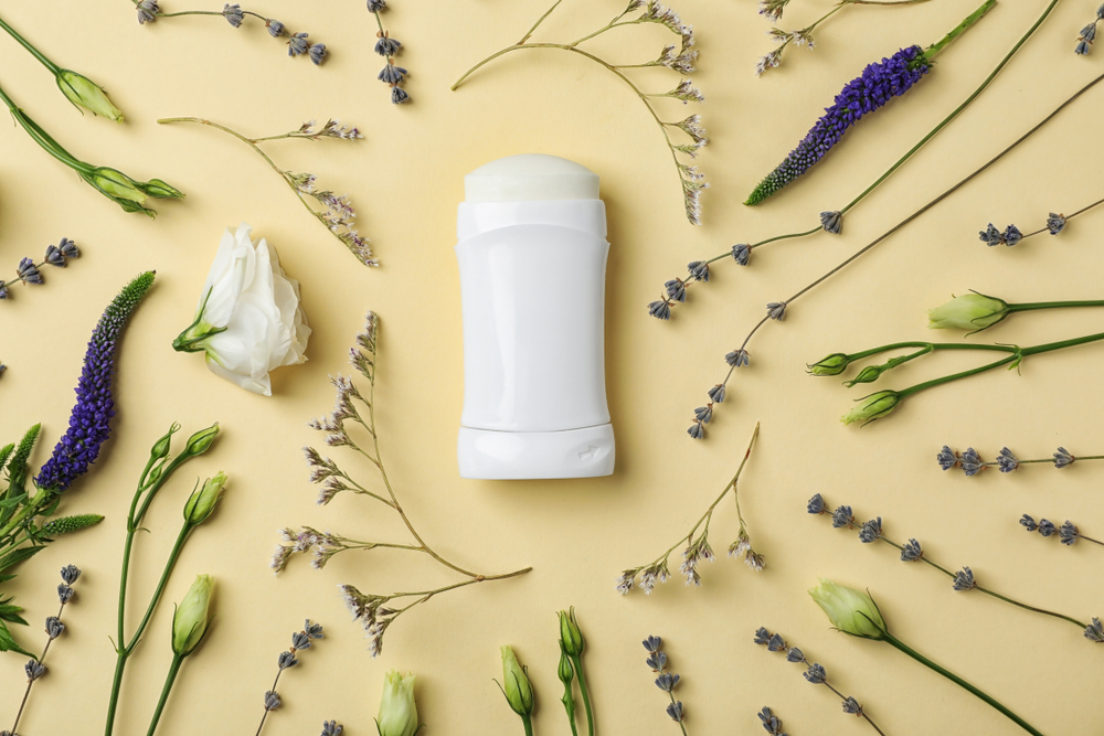 Natural deodorant stick surrounded by clean and non-toxic personal care items